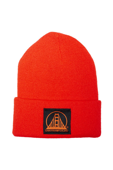 The Red Kids Beanie w/ Black/Red Logo is bright red with a cozy fit, featuring a black patch with an orange bridge design and the playful text San Franpsycho, perfect for kids who love cool style.