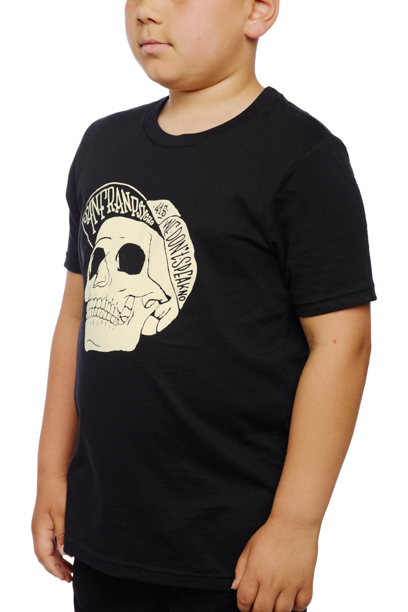 A young person models the Youth Black Street Skull Tee, showcasing a graphic of a Street Skull against a black background with eye-catching white text, made entirely from 100% cotton.