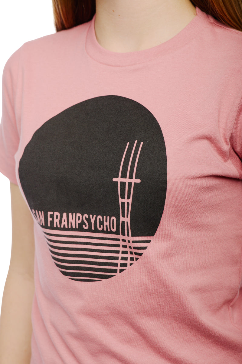 The Youth Sutro Tower Tee, crafted from 100% cotton, features a pastel pink color with a black abstract graphic and text design.