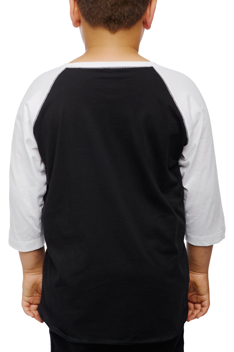 A child wearing a Youth Planet Rock Baseball Tee in classic black and white, exuding 90s vibes, stands with their back to the camera.