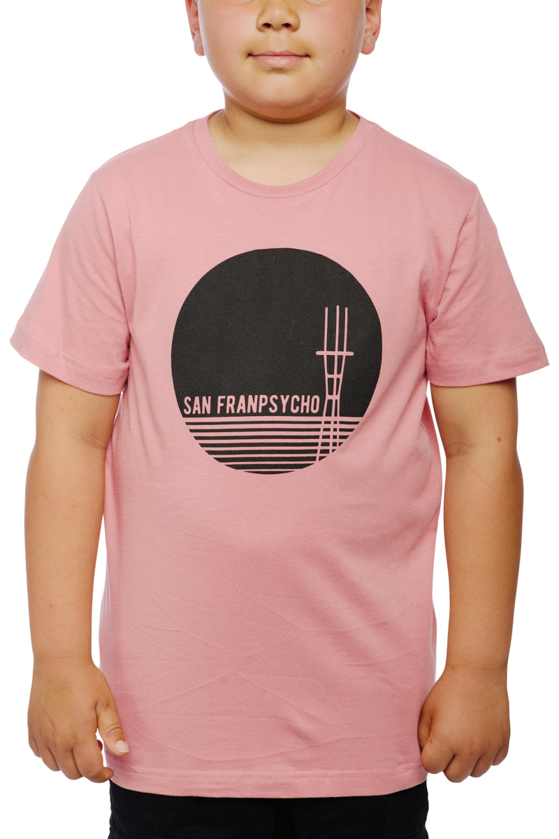 A child wearing a Youth Sutro Tower Tee in pastel pink features a black circle graphic with lines and a tower, made from 100% cotton.