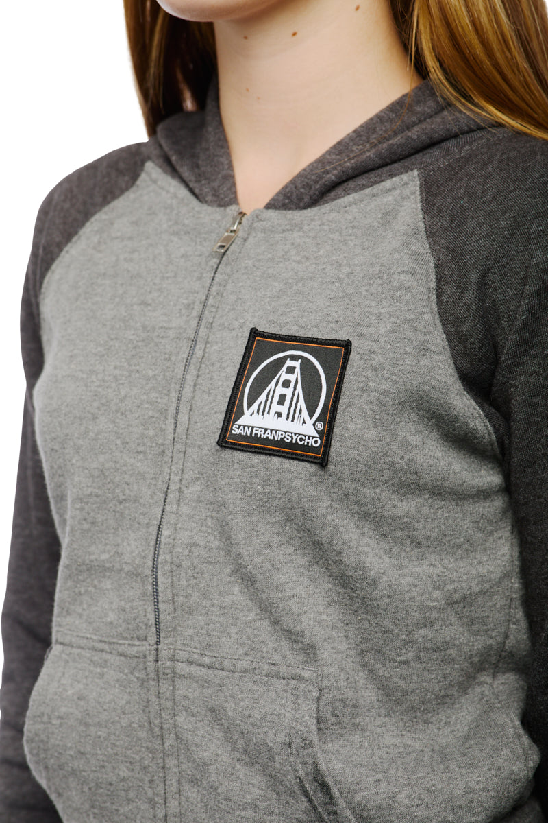 A person wearing the Youth Two Tone Patch Hoodie, featuring the iconic San Franpsycho logo on the chest, perfect for those who love stylish youth apparel.