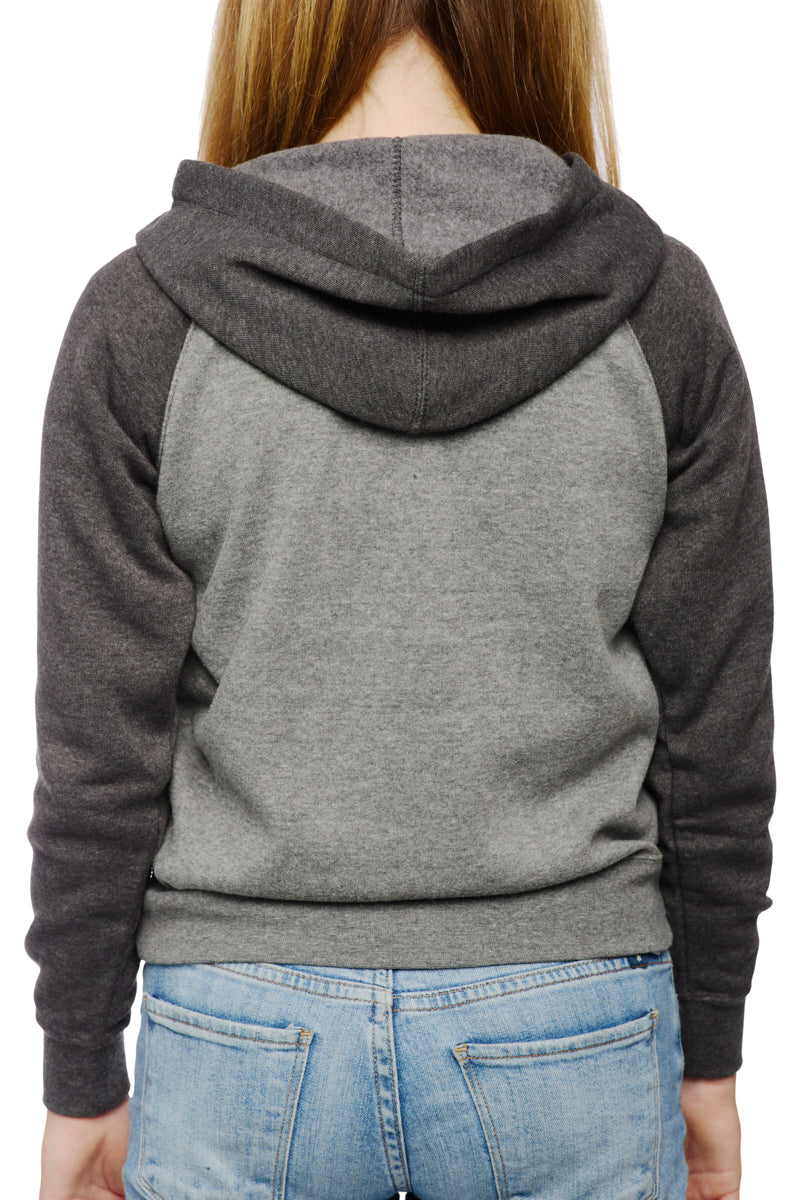 The person, wearing a Youth Two Tone Patch Hoodie by San Franpsycho in grey with dark sleeves and blue jeans, is seen from the back.