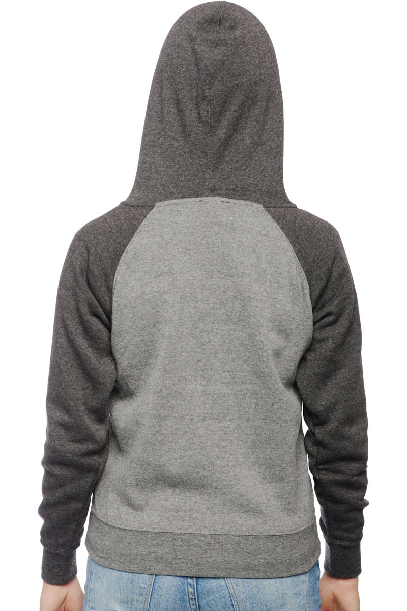 Wearing the Youth Two Tone Patch Hoodie in shades of gray that echo the lively San Franpsycho aesthetic, a person pairs it with blue jeans as they face away.