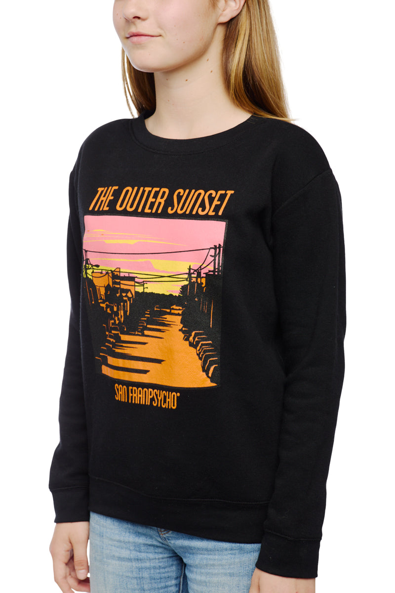 Wearing the Youth Outer Sunset Crewneck, featuring a hand-printed graphic and text, paired with jeans, perfectly captures the quintessential laid-back vibe of San Francisco.