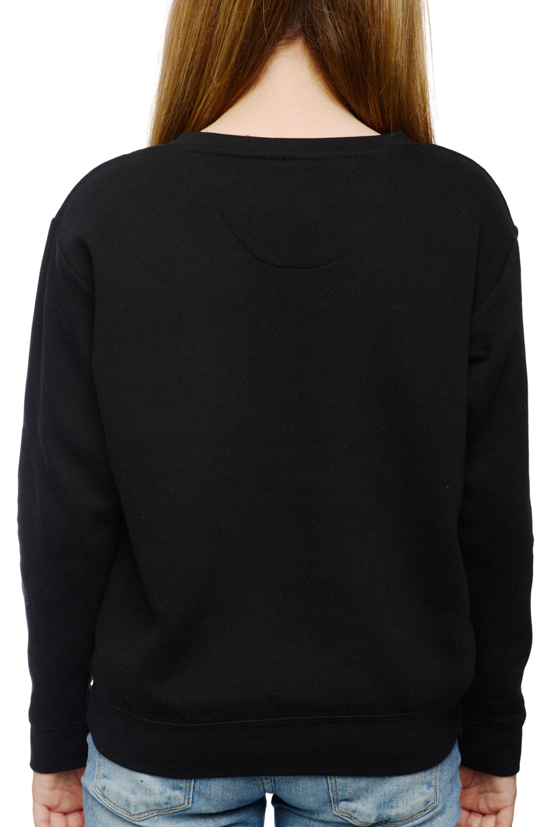 A person with long hair, wearing a hand-printed black Youth Outer Sunset Crewneck and blue jeans, is captured from behind while strolling through the Outer Sunset neighborhood of San Francisco.