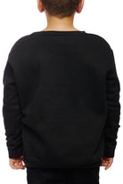 A child, wearing the Youth Outer Sunset Crewneck in hand-printed black, stands facing away from the camera against a stark white background.
