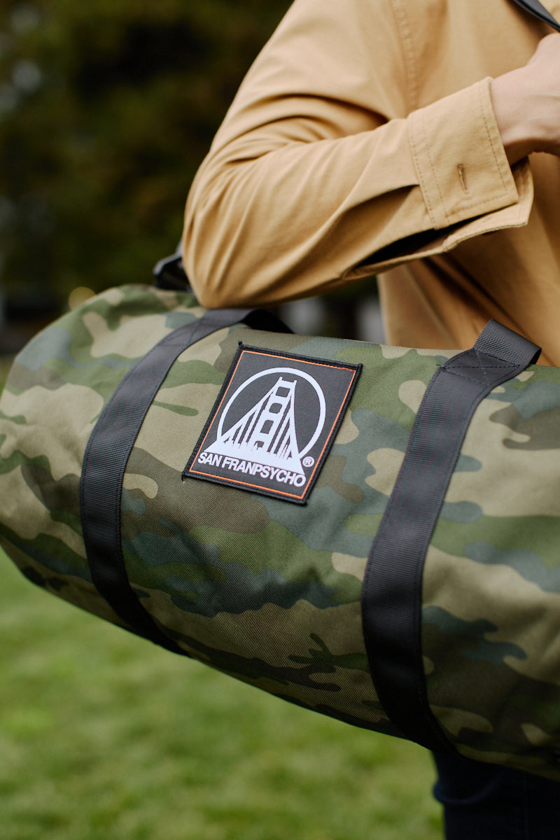 Someone carrying the SFP Patched Duffle Bag appreciates the convenience of its removable shoulder strap and the strength of durable polyester.