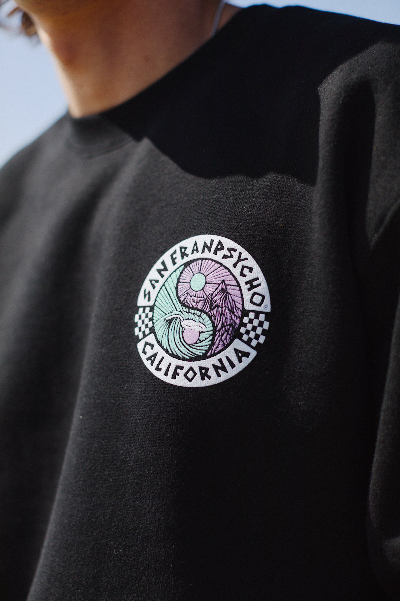 Close-up of the Yin-Yang Crewneck in black, showcasing a colorful, 80s-inspired San Franpsycho California logo with checkerboard accents. This piece from the lively Spring 2024 collection effortlessly combines retro flair with modern charm.