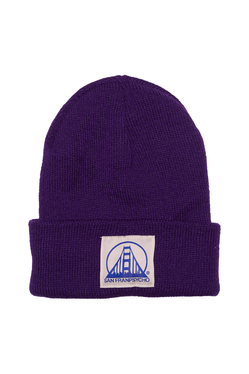 Keep your kids cozy with the Purple Kids Beanie w/ Natural/Blue Logo, featuring a folded brim and a patch with the Golden Gate Bridge and San Franpsycho text.