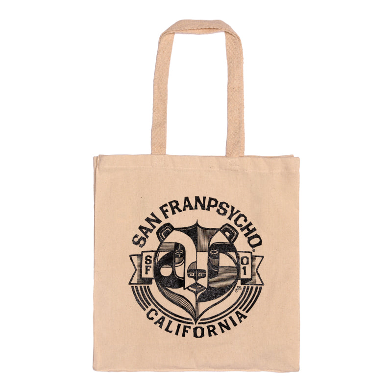 The Bear Essentials Tote is a beige canvas bag with "San Franpsycho California" and a bold black California bear graphic—an ideal accessory for San Francisco enthusiasts.