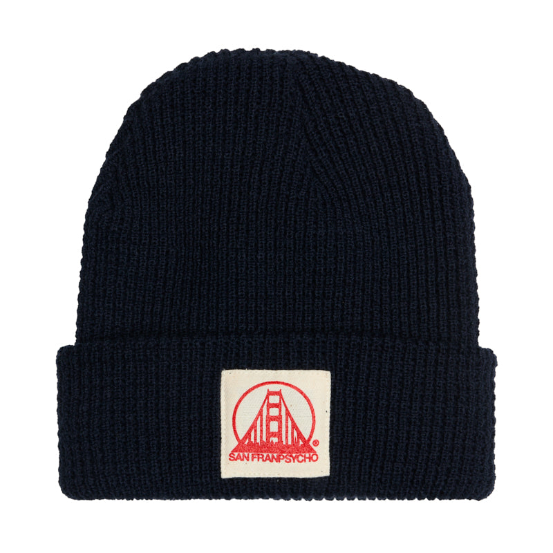 A navy acrylic waffle beanie featuring a patch with a natural and poppy San Francisco logo on the front, showcasing classic San Franpsycho style.