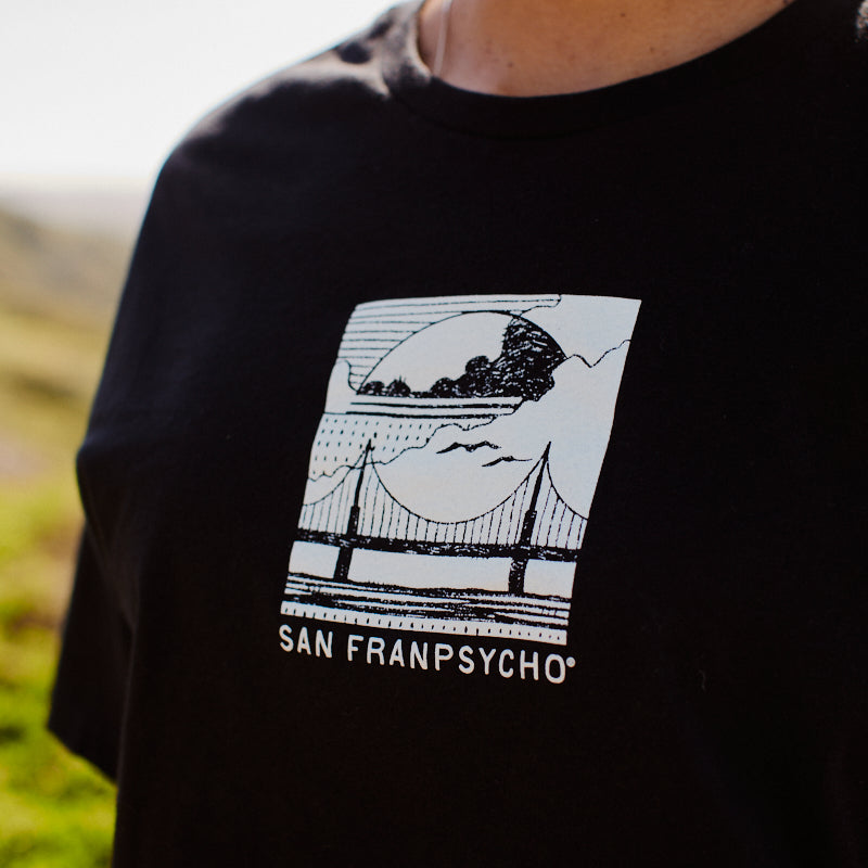 Model wears the Women's Elemental Cropped Tee in black, featuring a graphic bridge design and San Franpsycho text that captures the spirit of San Francisco.