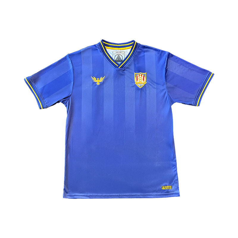 The WC x SFP Jersey - Blue is a short-sleeve soccer top with yellow details, dual crest logos on the chest, and a fan fit—perfect for US Men's National Team supporters and inspired by World Cup jerseys.