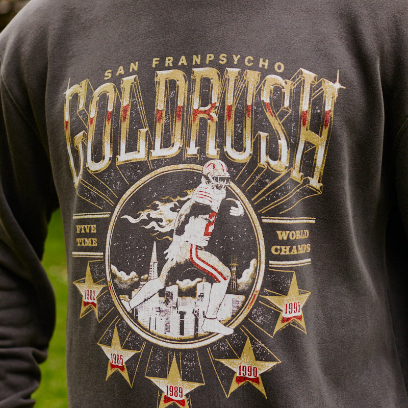 Person wearing the Gold Rush Crewneck featuring a dark 49ers design with a football graphic and championship years, perfect for San Francisco fans.