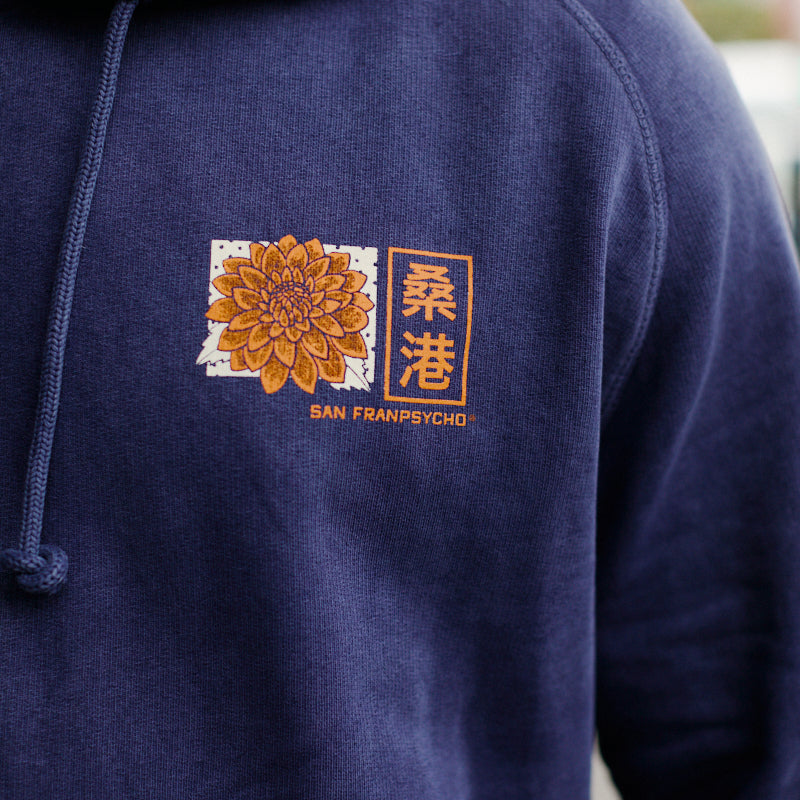 Wearing the Sunset Dahlia Pullover Hoodie, which features a yellow flower and Chinese characters above the San Franpsycho logo, hand printed in San Francisco.