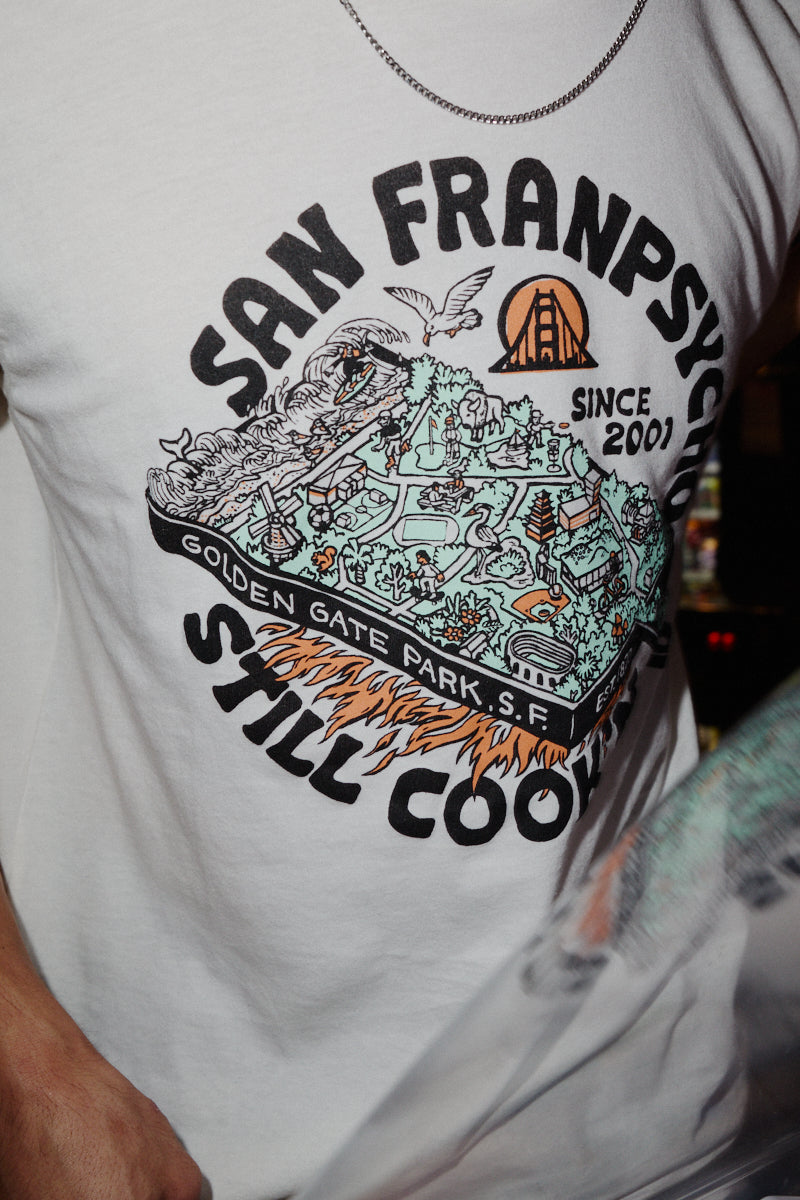 White Still Cookin’ Tee with a Golden Gate Park graphic featuring the text San Franpsycho and Still Cookin.