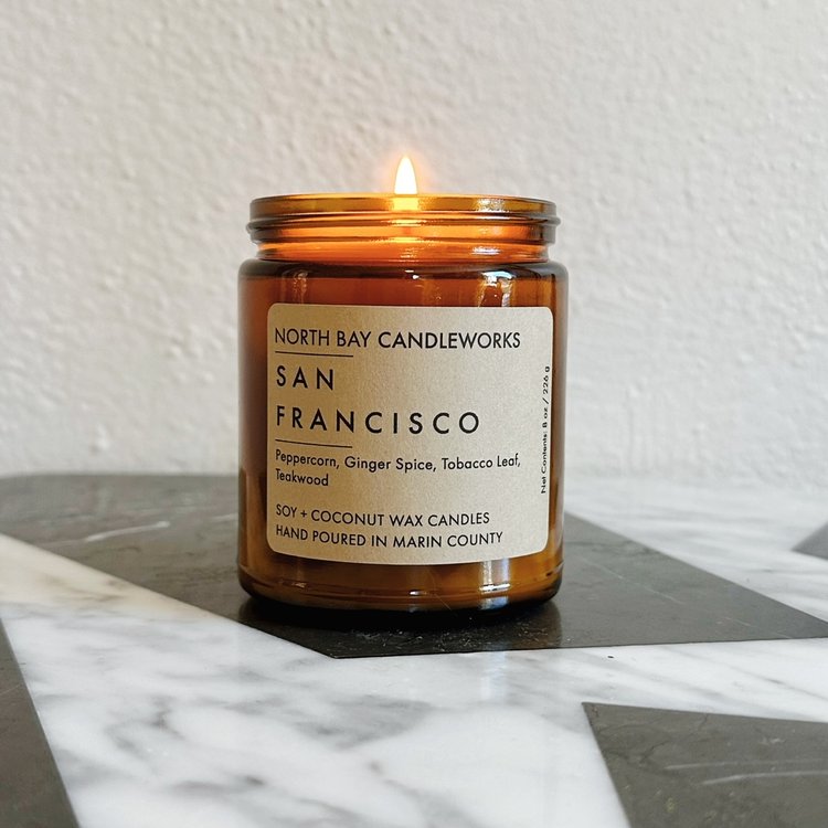 Amber candle from North Bay Candleworks labeled San Francisco, part of the Marin Landmark Line, resting elegantly on a marble surface.