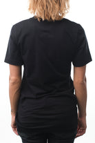 Rear view of a person wearing a super soft black Surf Club Tee and jeans against a white background.