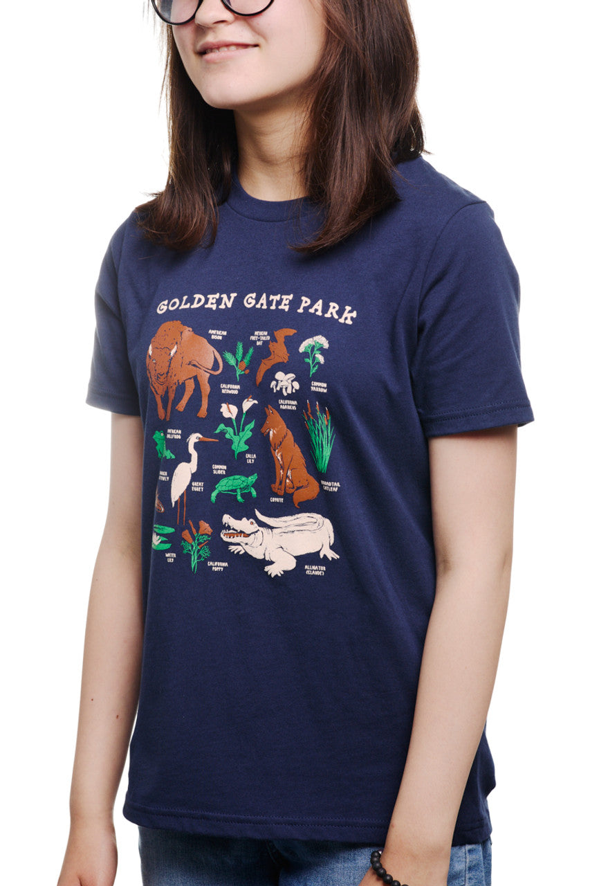 A person is wearing a Youth Golden Gate Park Animals Navy Tee, featuring charming animal illustrations and the words Golden Gate Park, giving it a playful vibe perfect for kids.
