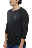 A man is posing against a white background, wearing the Charcoal Raglan w/ Mini Logo from the basics line, designed for everyday wear.