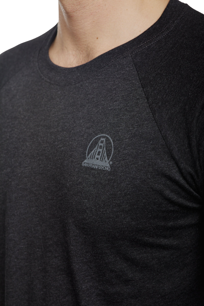 Dressed in the Charcoal Raglan w/ Mini Logo from the basics line, this individual sports a tee adorned with a subtle San Francisco bridge logo on the chest. Ideal for daily outfits, this shirt seamlessly blends comfort and style.