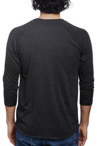 Viewed from the back, an individual wears a casual outfit consisting of a Charcoal Raglan with a Mini Logo and classic blue jeans.