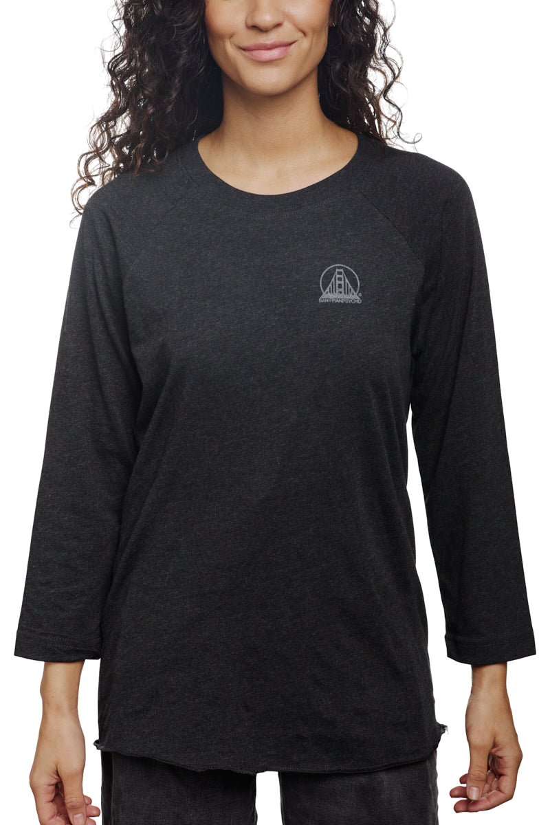 Woman wearing the Charcoal Raglan with Mini Logo, a black long-sleeve shirt from our basics line.