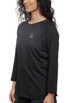 A person dressed in the Charcoal Raglan w/ Mini Logo from the basics line, ideal for everyday wear.