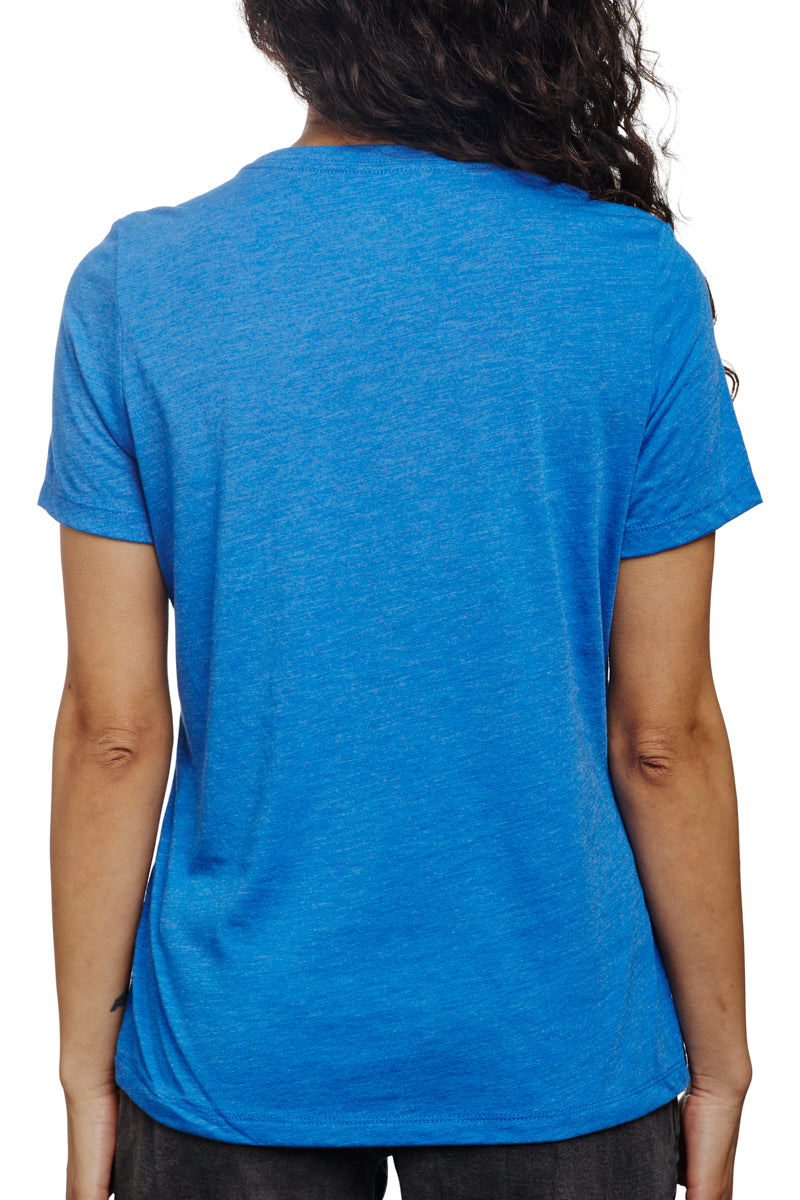 Rear view of an individual wearing the Women's Logo Tee in blue and gold, featuring wavy hair cascading over their shoulders.