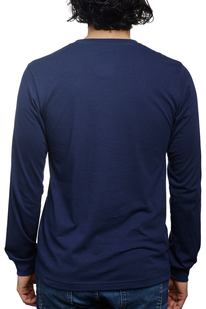 A person is seen from behind against a crisp white background, wearing the Navy Long Sleeve Mini Logo tee made from soft Airlume cotton, paired with jeans.