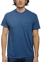 A person wearing the Heavyweight Midnight Pocket Tee, a plain blue heavyweight shirt made of garment dyed cotton, featuring a practical chest pocket.