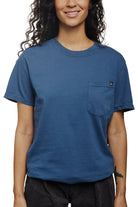A smiling person with long hair is wearing a Heavyweight Midnight Pocket Tee.