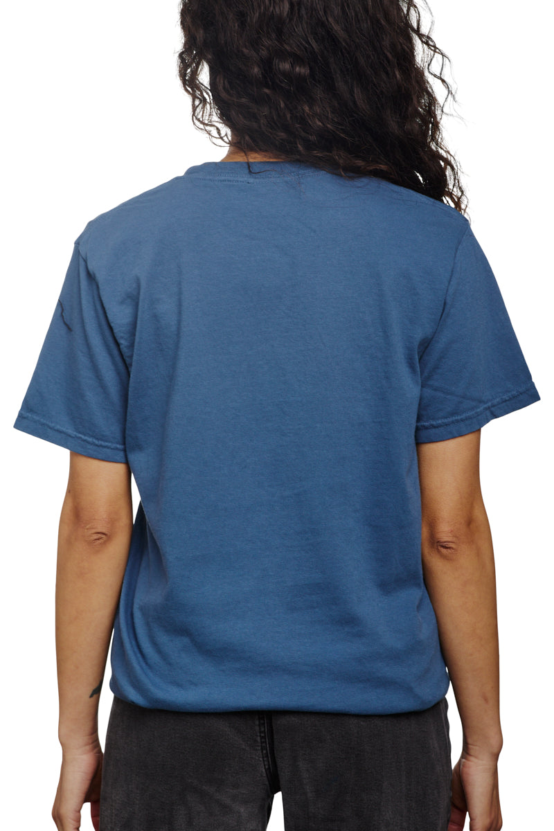 A person with long hair is seen from the back, wearing a Heavyweight Midnight Pocket Tee and black pants.
