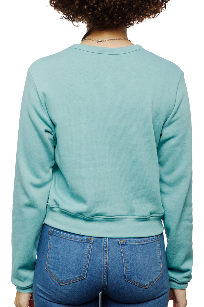 Someone dressed in a teal Trippy Psycho Women's Crewneck and jeans is observed from behind. This ultra-soft cotton/polyester blend piece is included in the Spring 2023 Collection.