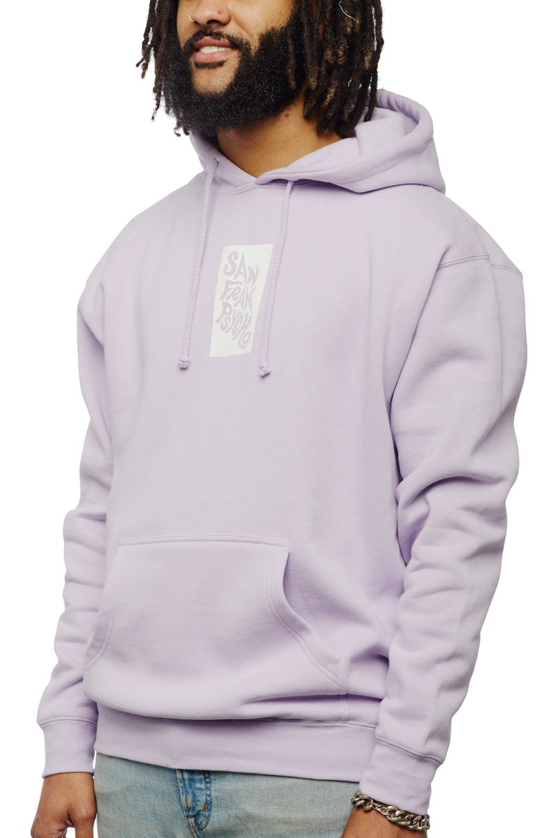A man wearing a lavender Trippy Psycho Pullover Hoodie from the Spring 2023 Collection, featuring the San Fran Psycho logo, stands with his hands in his pockets.