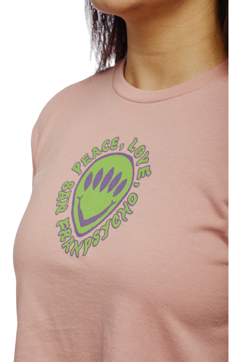 A person wearing a vibrant pink T-shirt featuring a green and purple graphic boldly declares "NYC Peace, Love, Frank Psycho," reminiscent of the playful charm found in the Peace Love Alien Crop Top.