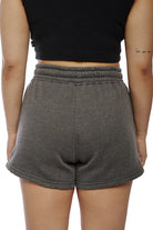 A person is seen from the back, wearing a black crop top paired with stylish Women's Embroidered Logo Jogger Shorts in a soft cotton/polyester blend.