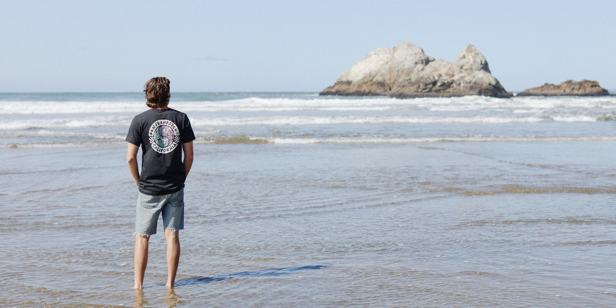man standing on the beach wearing the yin yang tee
