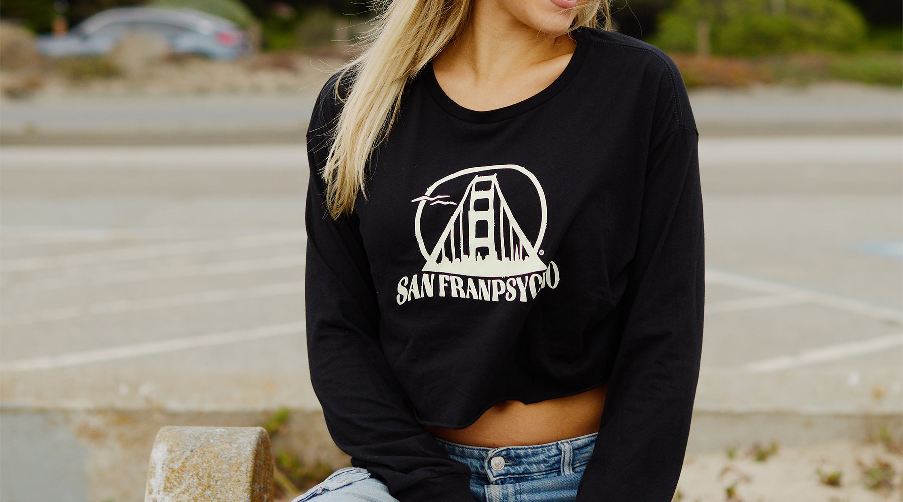 woman looking at surfboards wearing cat stamp cropped hoodie