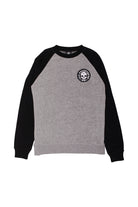 The BBNW Skull Patched Raglan Crewneck is a gray and black sweatshirt with a circular skull logo on the chest, ideal for achieving a punk rock look.