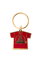 Gold Logo Tee Keychain with a red shirt-shaped pendant, featuring a black enamel stylized tower design.