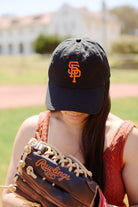 Wearing the Psychos Dad Hat, marked by an embroidered logo, a person with a baseball glove gazes down on a sunny field.