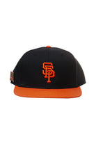 Psychos Logo Snapback w/Pin: A black and orange snapback baseball cap featuring an embroidered SF logo on the front, an orange brim, and an adjustable back for a perfect fit.