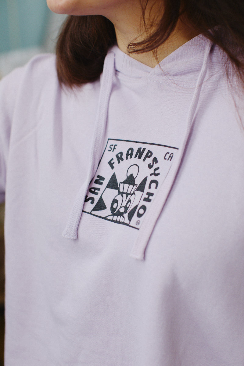 A woman is wearing a Lavender Cat Stamp Crop Hoodie featuring a San Franpsycho graphic on the front.