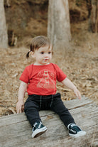 toddler sitting on log wearing Red Fogtown Onesie
