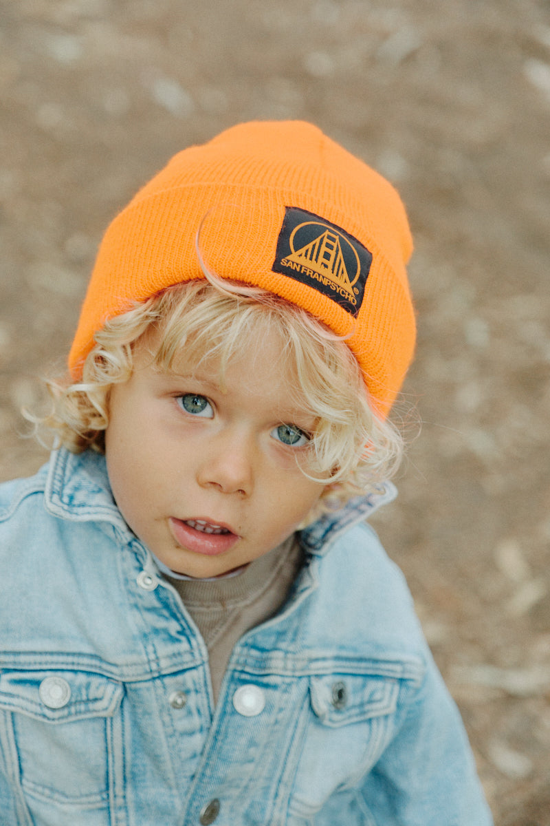 boy wearing Orange Kids Beanie w/ Black/Orange Logo
