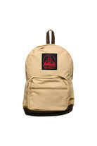 The Khaki Backpack w/ Build Bridges Not Walls Patch has leather trims and a front pocket featuring a patch with a bridge design.