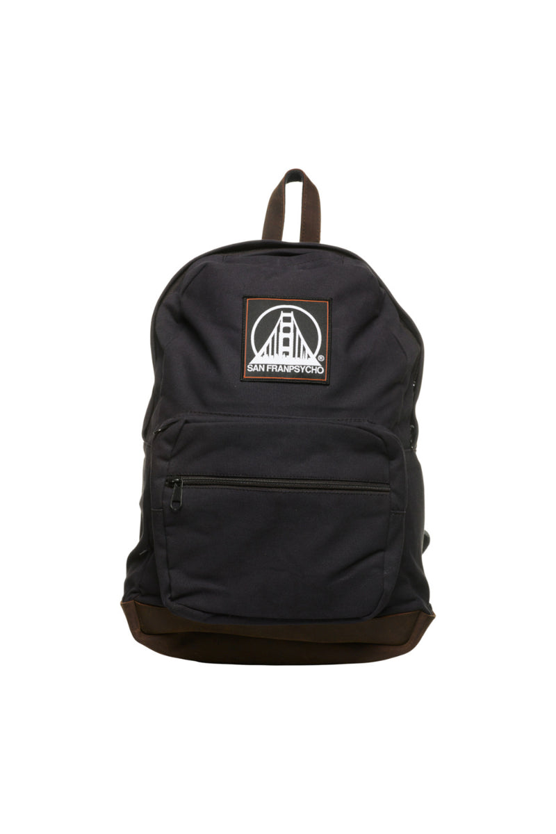 The Black Backpack w/ SFP Patch features leather trims, a front zipper pocket, and an iconic SFP Logo Patch with a bridge emblem, capturing the spirit of San Francisco.