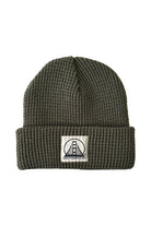 The Olive Waffle Beanie with a Natural/Black Logo, crafted by San Franpsycho, features a folded brim and logo patch with a stylized bridge design, combining comfort and style in one package. Its renowned for being the softest beanie available.